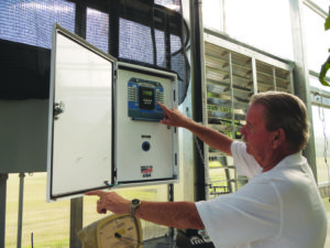 Tim Gallagher shows off the computer that controls the climate inside of the 7 Spruce Farm greenhouse. 