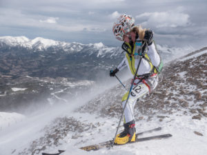 The 2015 first-place female finisher Michela Adrian braves the gusty winds on top of Lone Mountain.  